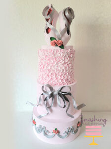 Four layer fake cake ballet theme cake color pink and grey.